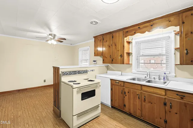 a kitchen with a stove cabinets and wooden floor