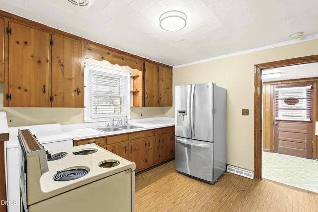 a kitchen with a refrigerator sink and cabinets