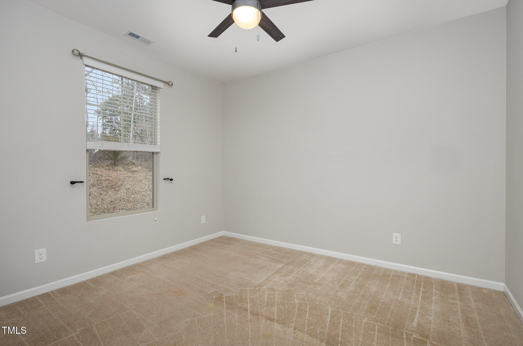 131 Kinnakeet Drive Durham, NC 27704 - Photo 11 of 18 an empty room with a window and a ceiling fan