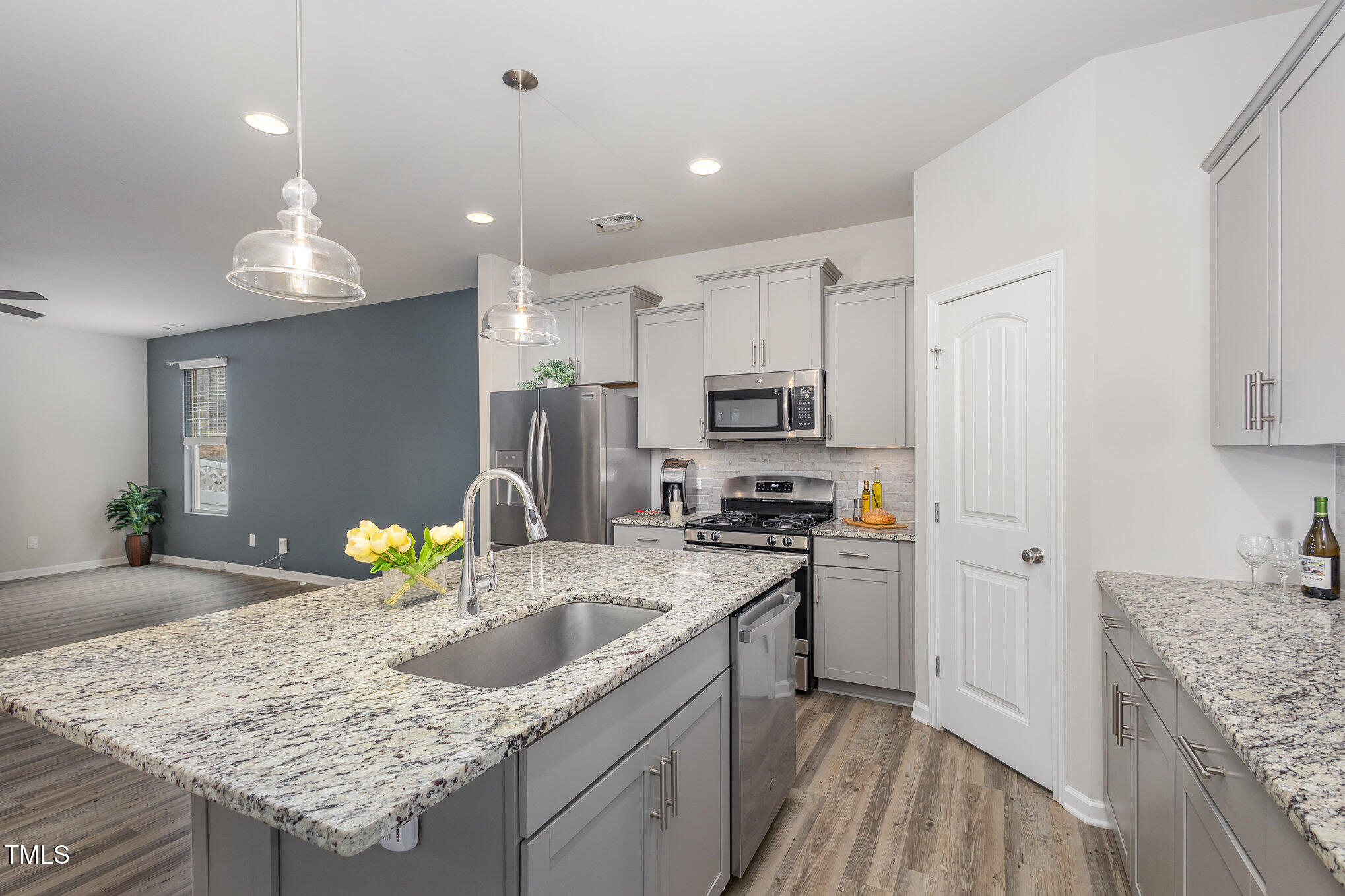 131 Kinnakeet Drive Durham, NC 27704 - Photo 5 of 18 a kitchen with granite countertop kitchen island a sink stainless steel appliances and white cabinets