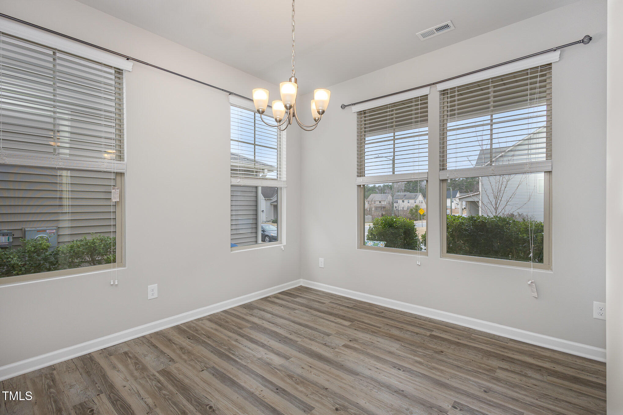 131 Kinnakeet Drive Durham, NC 27704 - Photo 6 of 18 a view of an empty room with wooden floor and a window