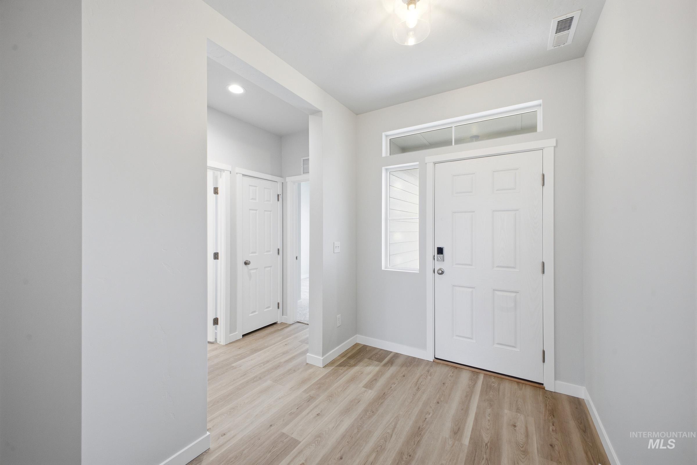 14104 Shiny Spruce Street Caldwell, ID 83607 - Photo 17 of 20 Entryway featuring wood-finish flooring, a six-panel door with transom window, and recessed lighting