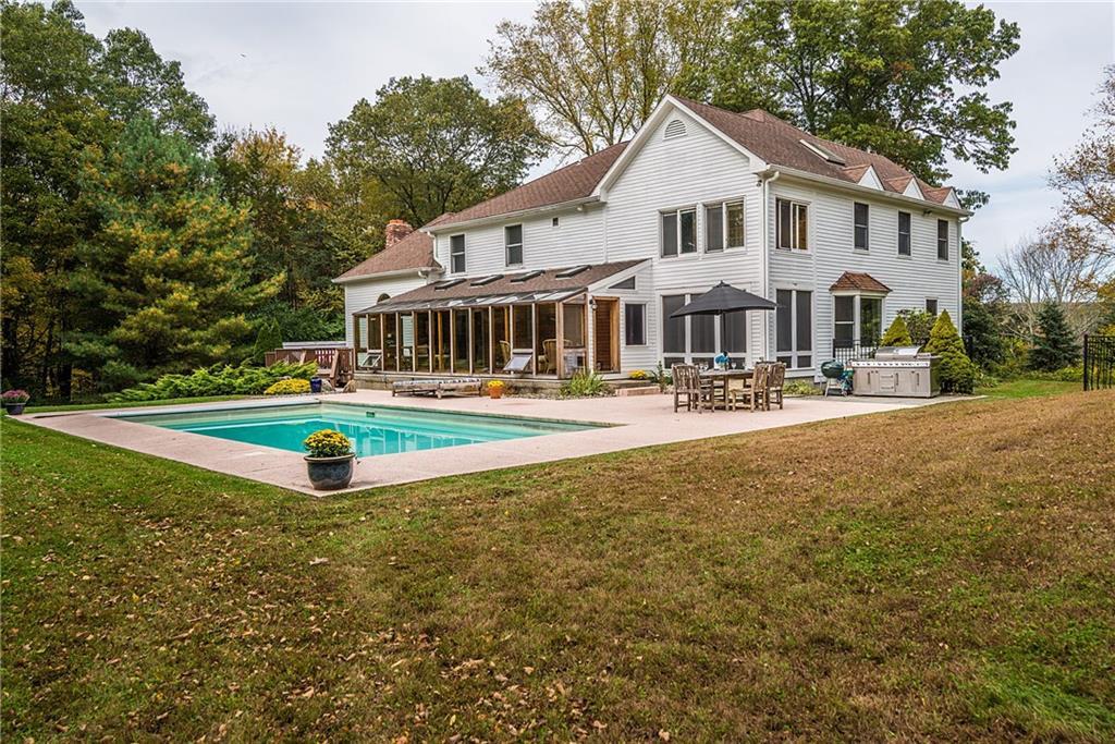 a front view of a house with garden and trees