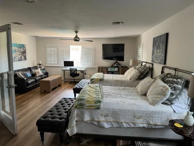 a bedroom with a bed couch and a window