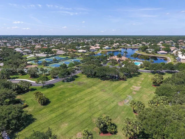 an aerial view of residential houses with outdoor space and trees