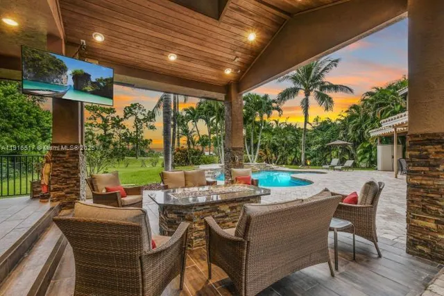 a view of a patio with couches table and chairs and potted plants
