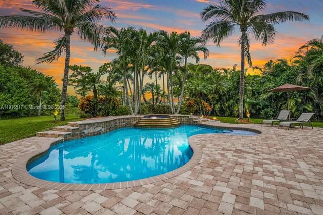 a view of a patio with couches table and chairs with potted plants and a barbeque