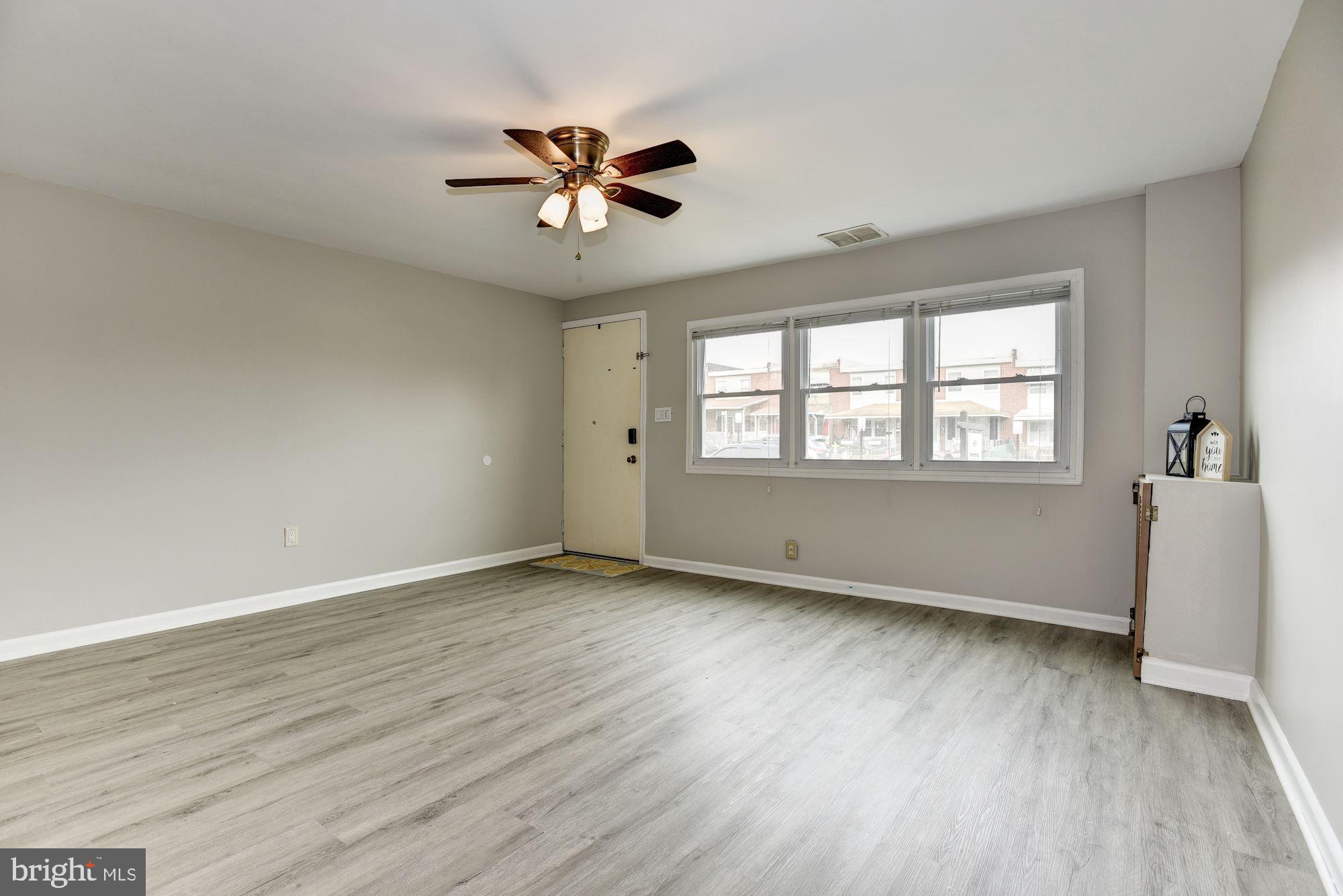 2759 Yarnall Road Baltimore, MD 21227 - Photo 3 of 21 a view of an empty room with wooden floor and a window