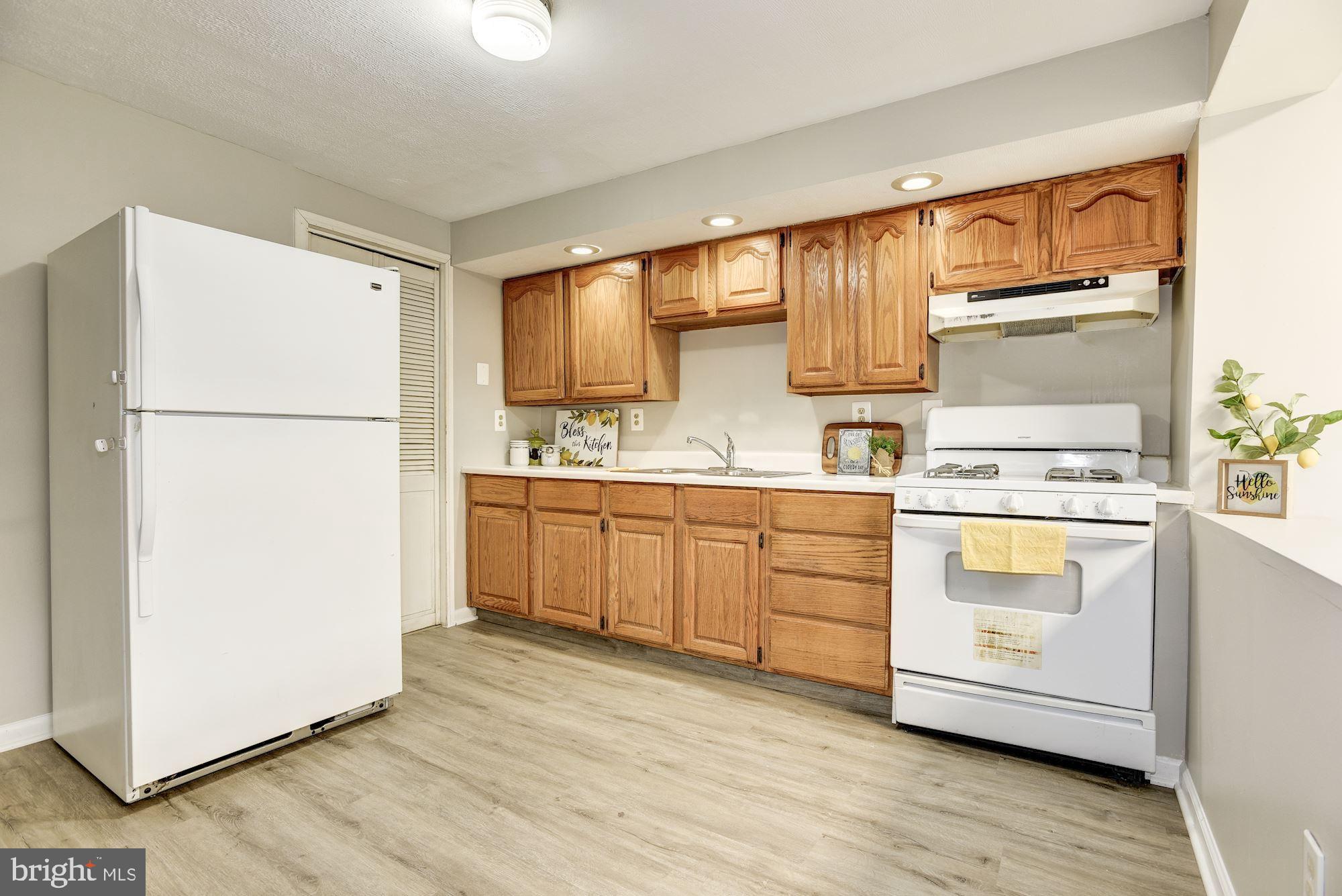 2759 Yarnall Road Baltimore, MD 21227 - Photo 5 of 21 a kitchen with white cabinets and white appliances
