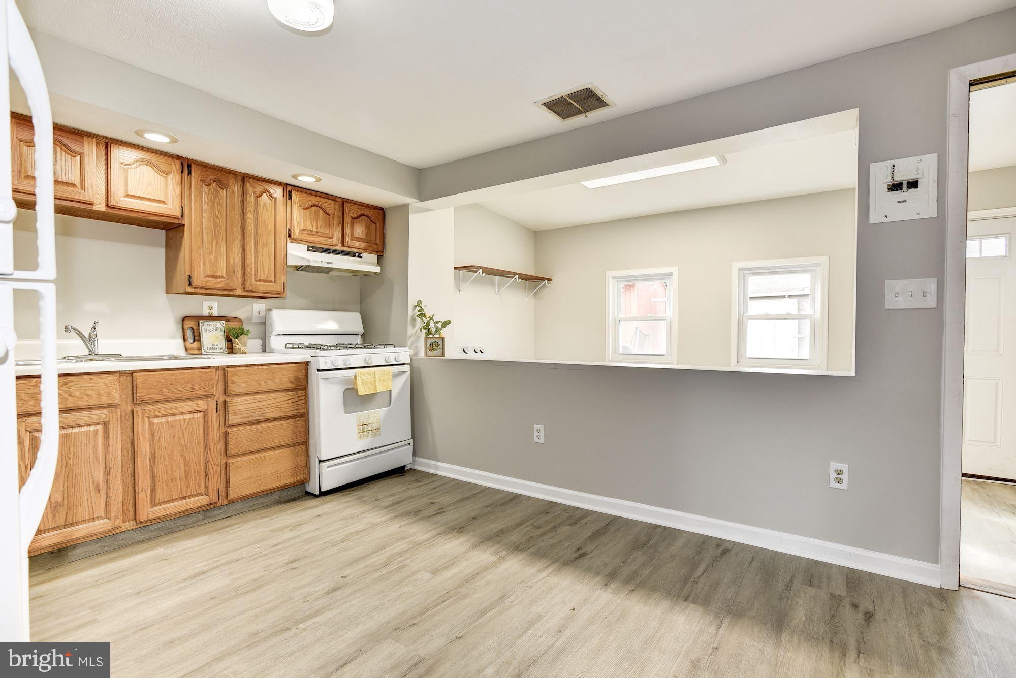 2759 Yarnall Road Baltimore, MD 21227 - Photo 7 of 21 a kitchen with granite countertop white cabinets and white appliances