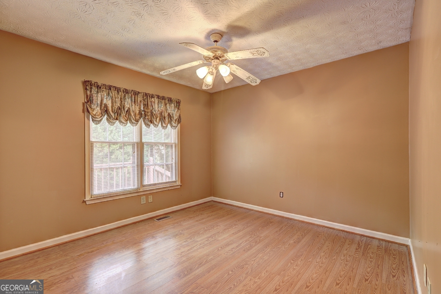 215 Laney Road McDonough, GA 30252 - Photo 21 of 38 an empty room with wooden floor fan and windows