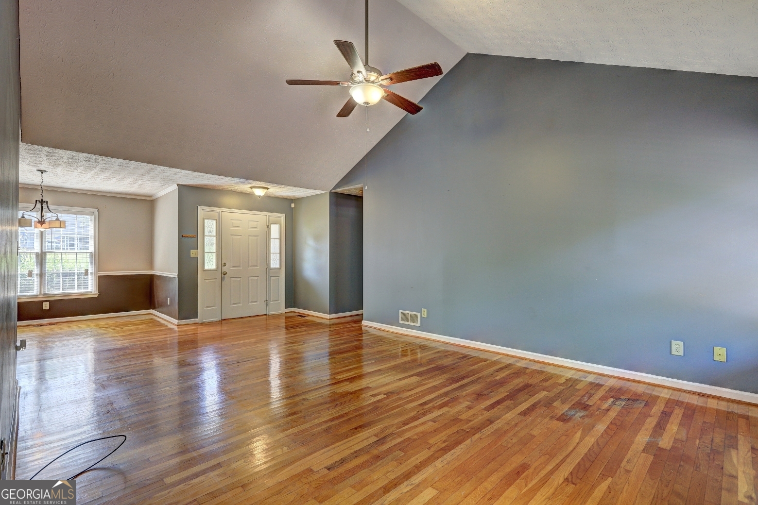 215 Laney Road McDonough, GA 30252 - Photo 5 of 38 a view of an empty room with wooden floor and a ceiling fan