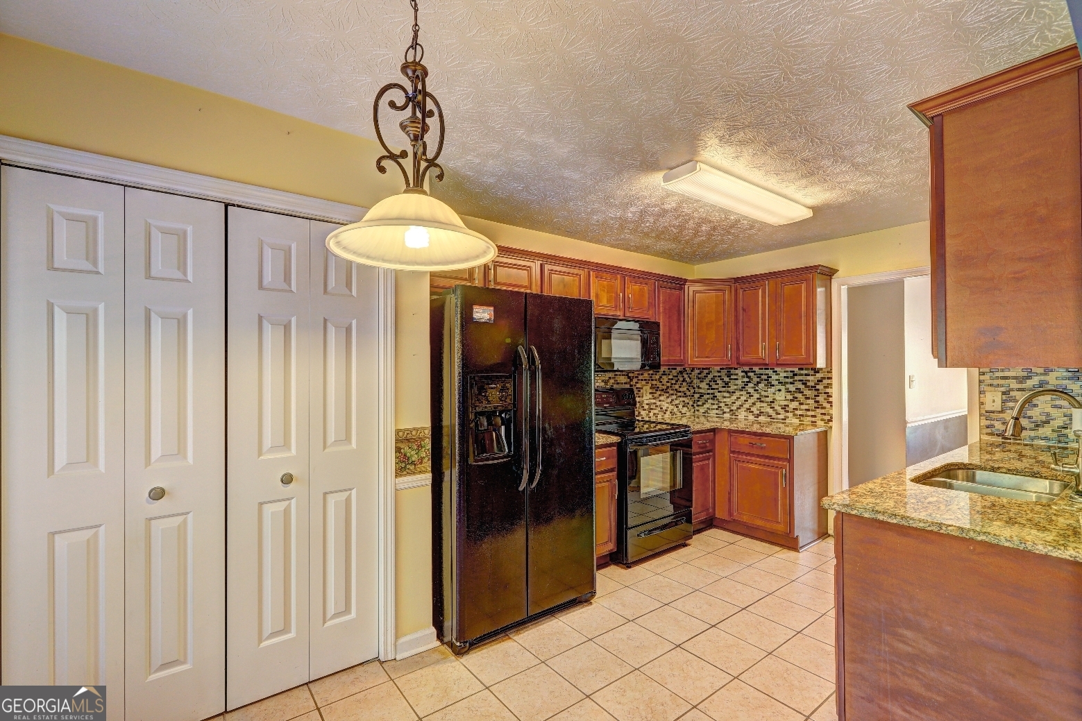 215 Laney Road McDonough, GA 30252 - Photo 6 of 38 a kitchen island with stainless steel appliances granite countertop furniture and a chandelier