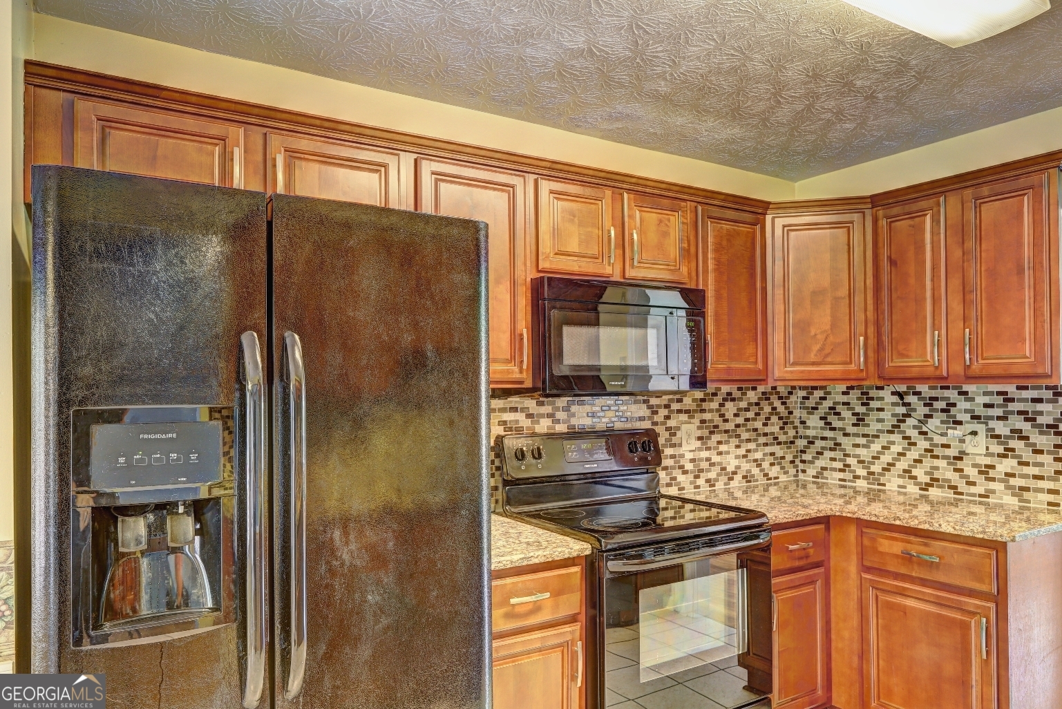 215 Laney Road McDonough, GA 30252 - Photo 8 of 38 a kitchen with a refrigerator a stove and cabinets