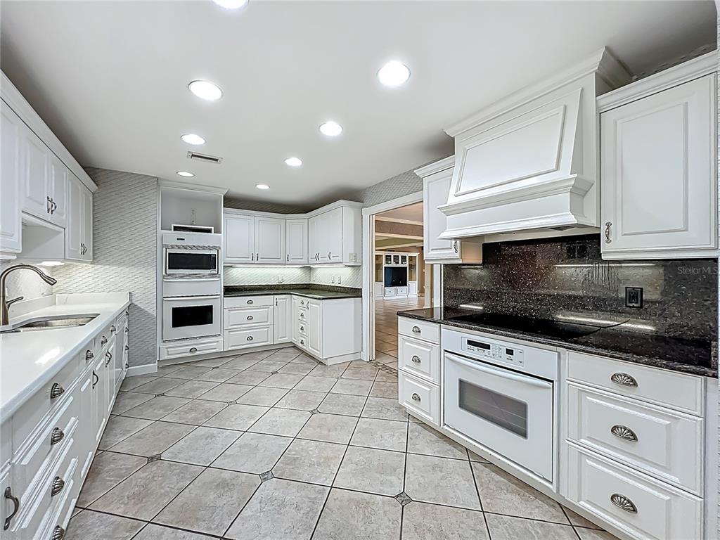 504 Banning Beach Road Tavares, FL 32778 - Photo 14 of 44 a kitchen with white cabinets appliances and a sink