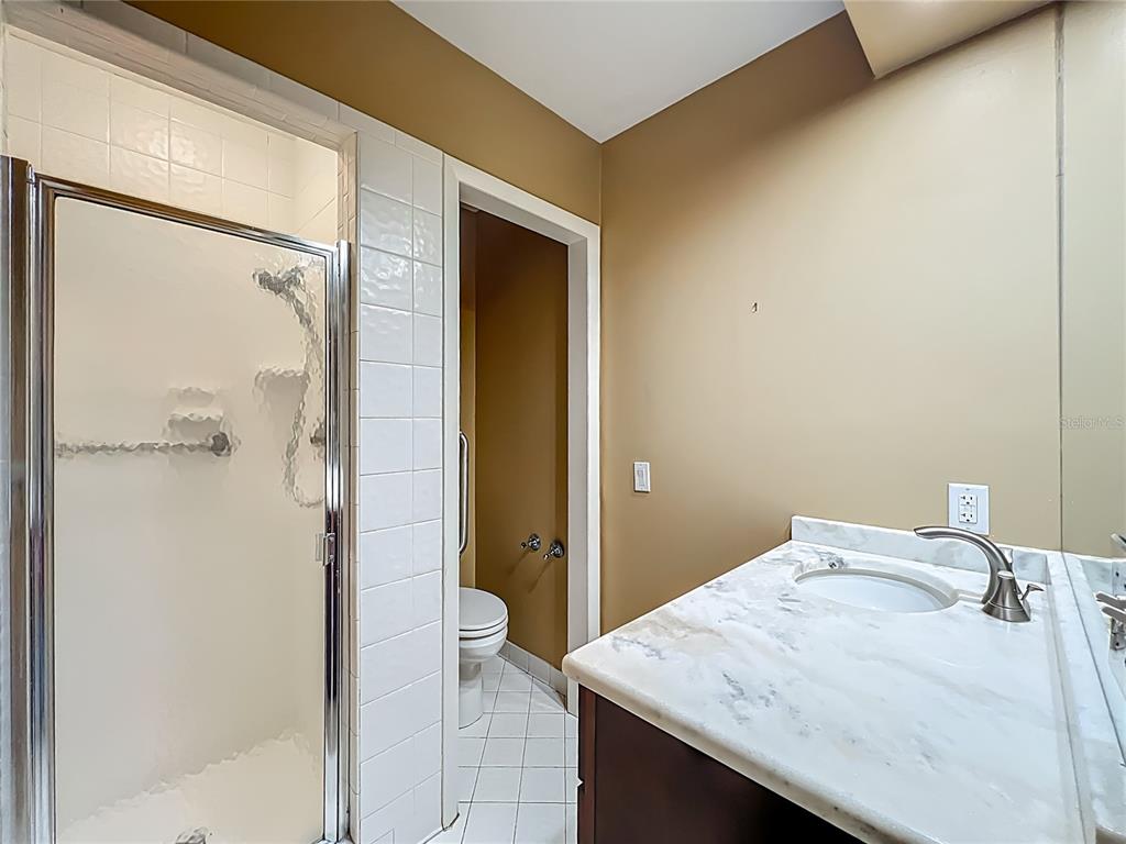 504 Banning Beach Road Tavares, FL 32778 - Photo 24 of 44 a bathroom with a granite countertop sink mirror and shower