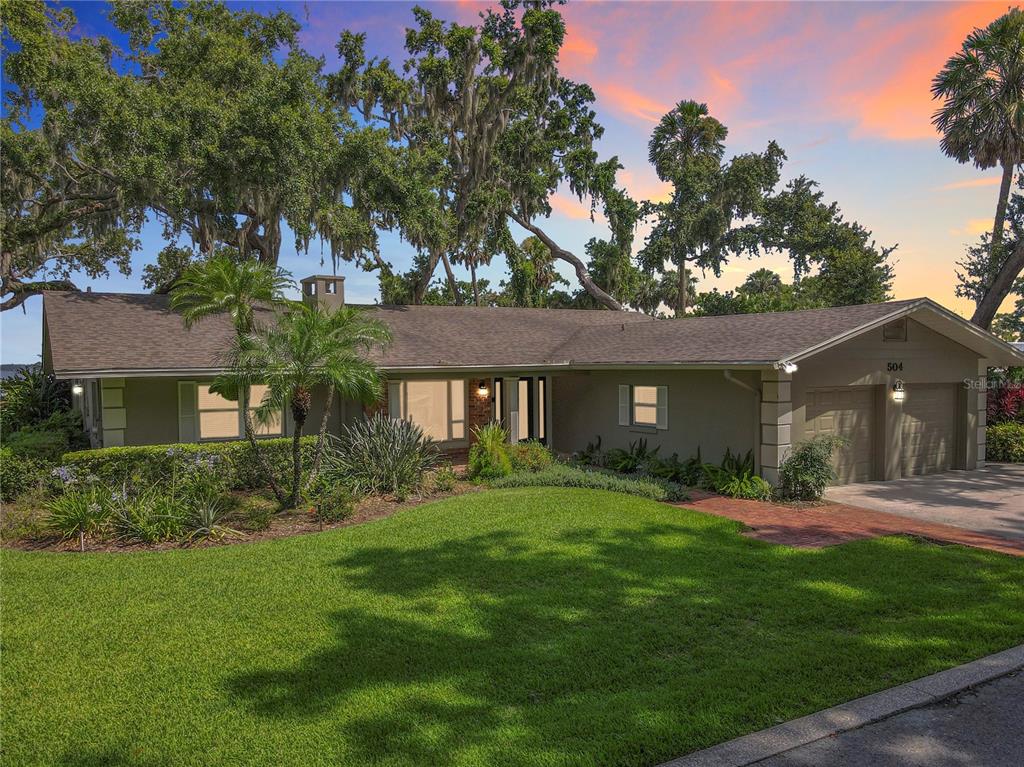 504 Banning Beach Road Tavares, FL 32778 - Photo 4 of 44 a front view of a house with a yard and trees