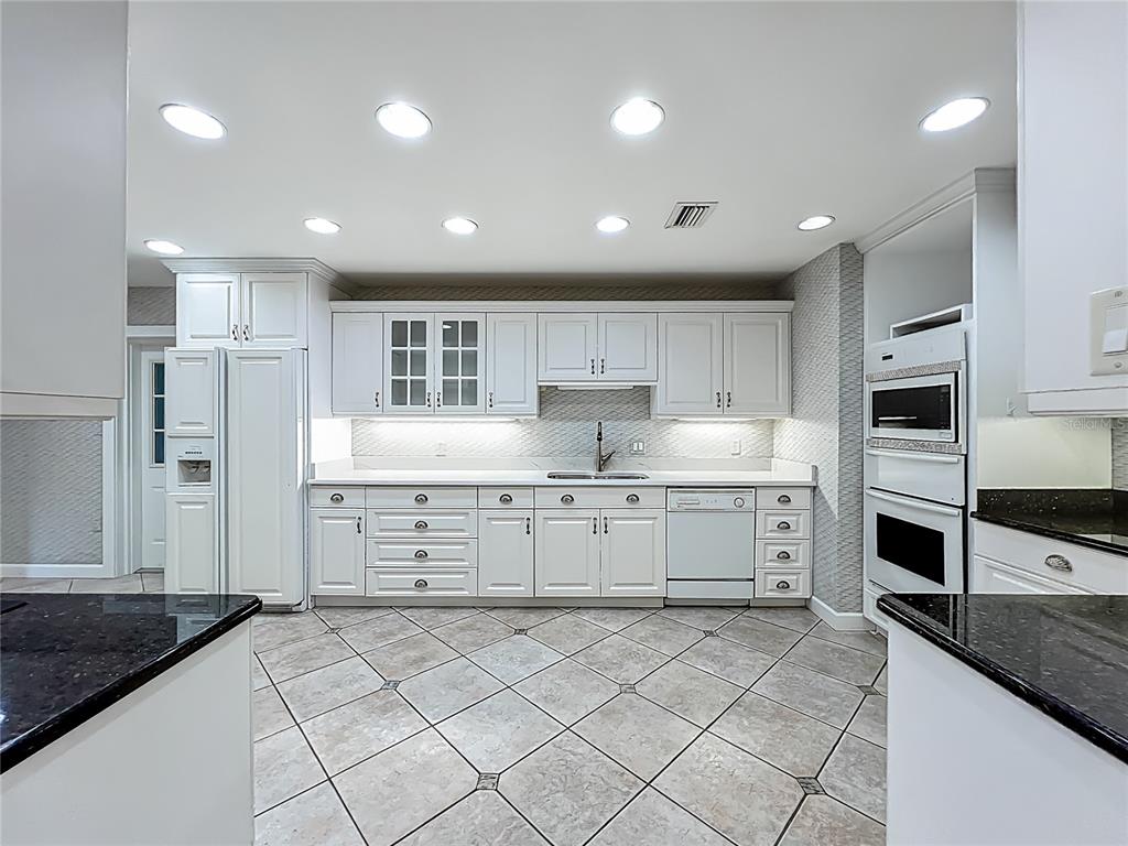 504 Banning Beach Road Tavares, FL 32778 - Photo 10 of 44 a kitchen with white cabinets and appliances