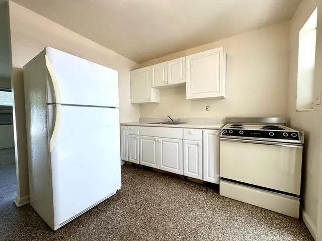 a kitchen with a refrigerator sink stove and cabinets