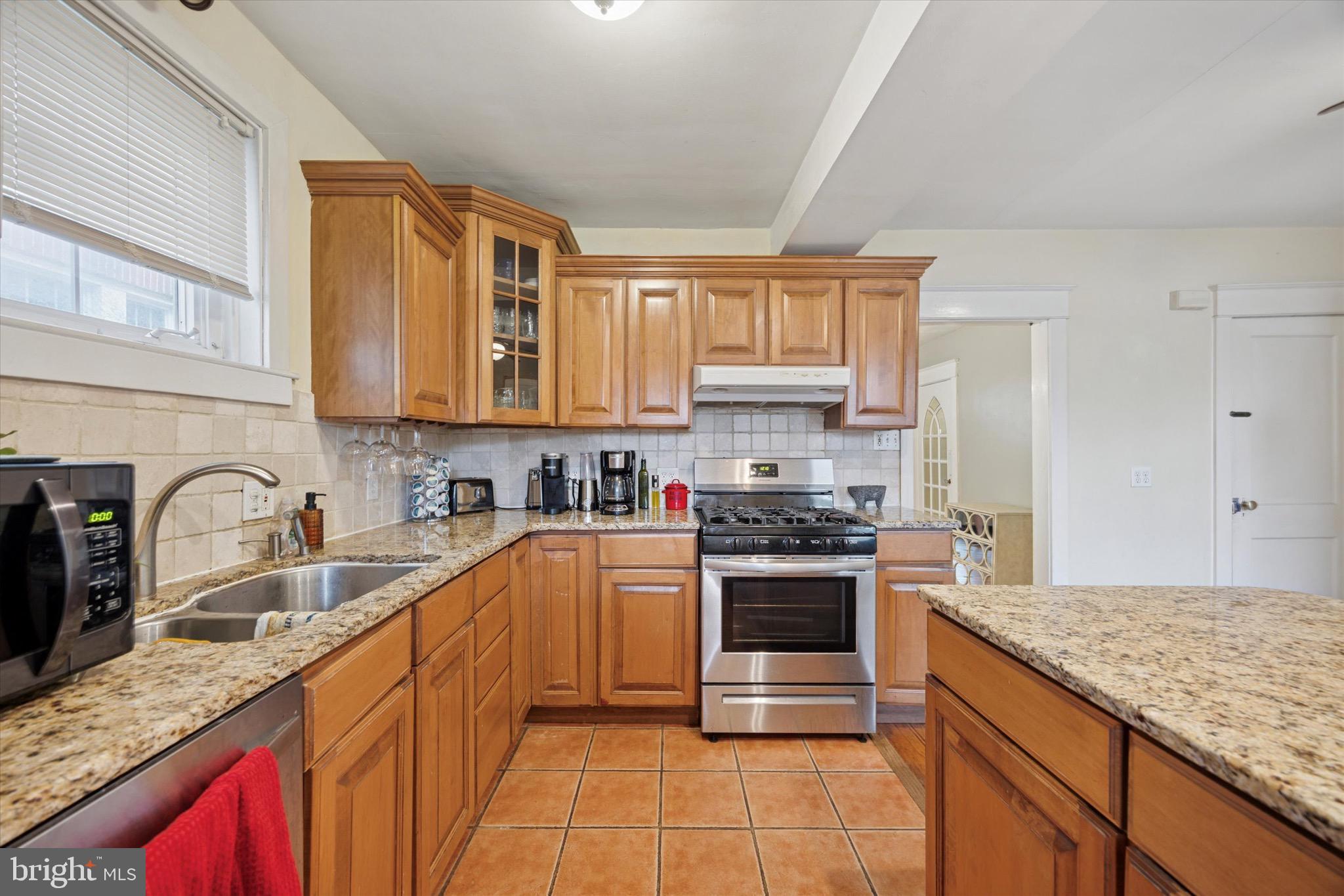 4930 State Road Drexel Hill, PA 19026 - Photo 6 of 18 a kitchen with stainless steel appliances granite countertop a sink stove and cabinets