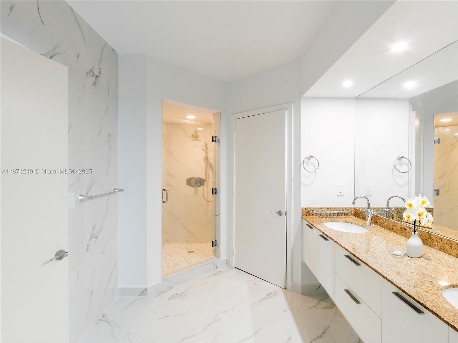 400 Alton Road, Unit 1104 Miami Beach, FL 33139 - Photo 11 of 27 a spacious bathroom with a granite countertop sink a mirror and a shower