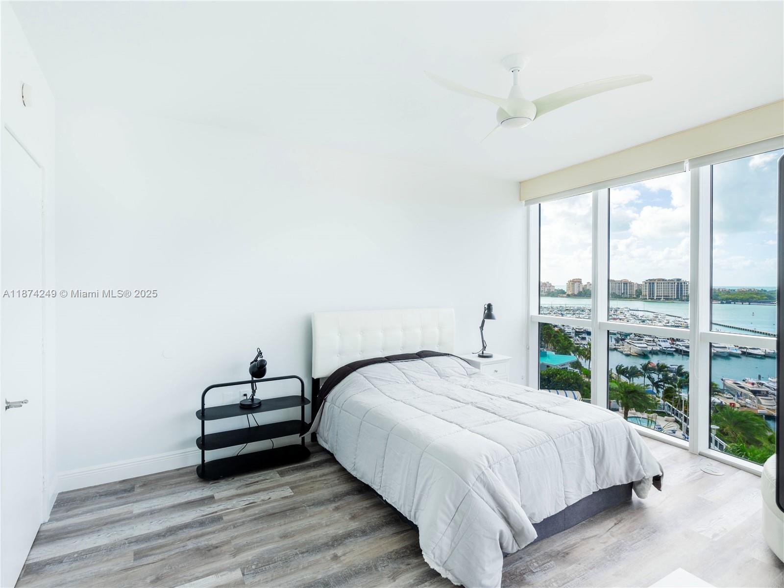 400 Alton Road, Unit 1104 Miami Beach, FL 33139 - Photo 14 of 27 a bedroom with a bed and a large window