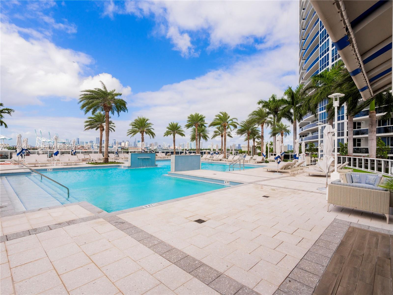400 Alton Road, Unit 1104 Miami Beach, FL 33139 - Photo 22 of 27 a view of a swimming pool with a lawn chairs under an umbrella