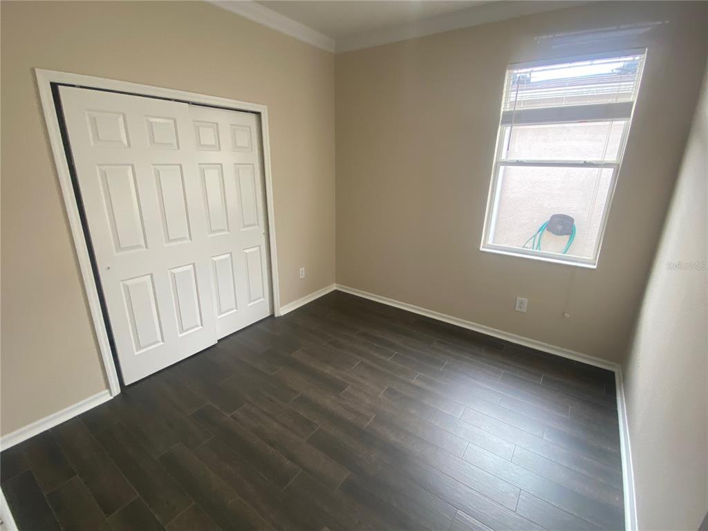 2409 Spring Hollow Loop Wesley Chapel, FL 33544 - Photo 13 of 47 an empty room with wooden floor and windows