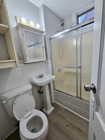 a bathroom with a toilet a sink and mirror