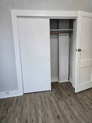 an empty room with wooden floor and closet