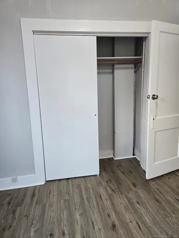 an empty room with wooden floor and closet