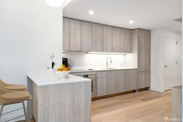 a kitchen with a sink cabinets and wooden floor