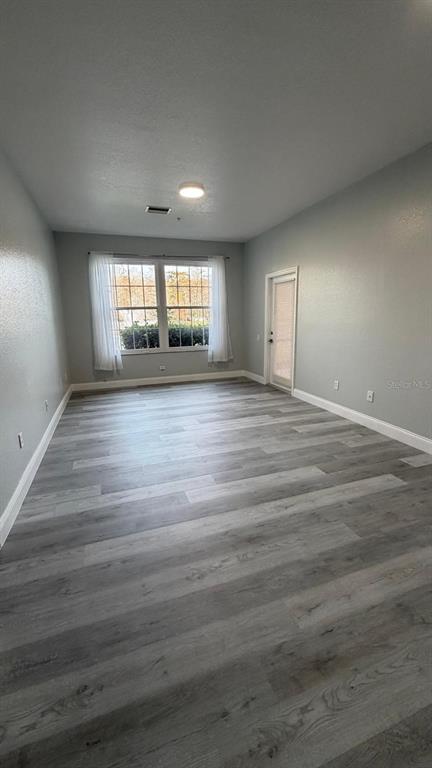 13584 Turtle Marsh Loop, Unit 113 Orlando, FL 32837 - Photo 11 of 29 an empty room with wooden floor and windows