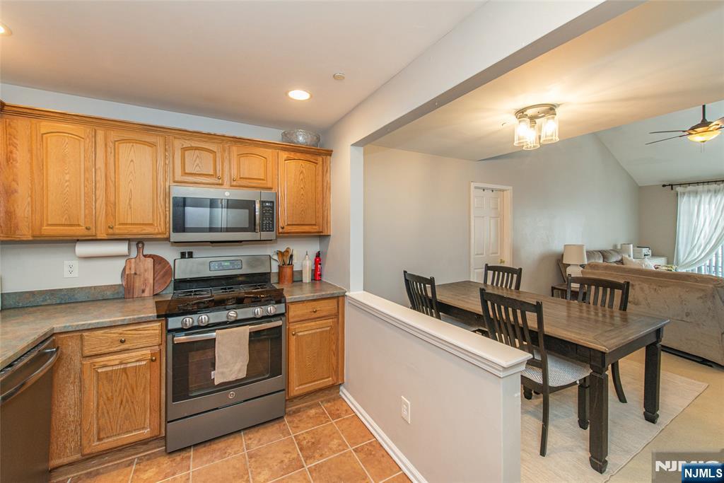 454 Cambridge Drive Butler, NJ 07405 - Photo 6 of 38 a kitchen with stainless steel appliances a stove a sink island and a refrigerator