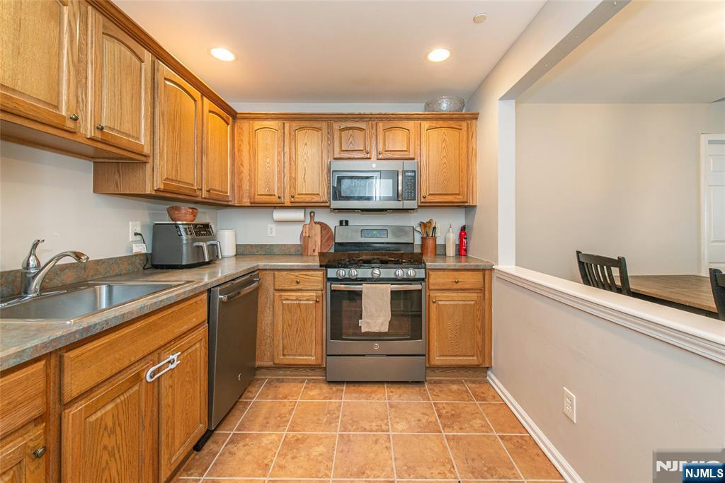 454 Cambridge Drive Butler, NJ 07405 - Photo 7 of 38 a kitchen with a stove top oven sink and cabinets
