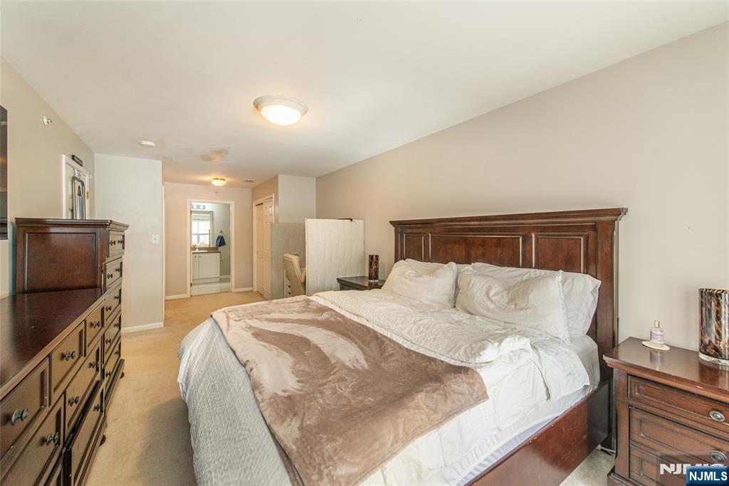 454 Cambridge Drive Butler, NJ 07405 - Photo 9 of 38 a large bed sitting in a bedroom next to a window with tv