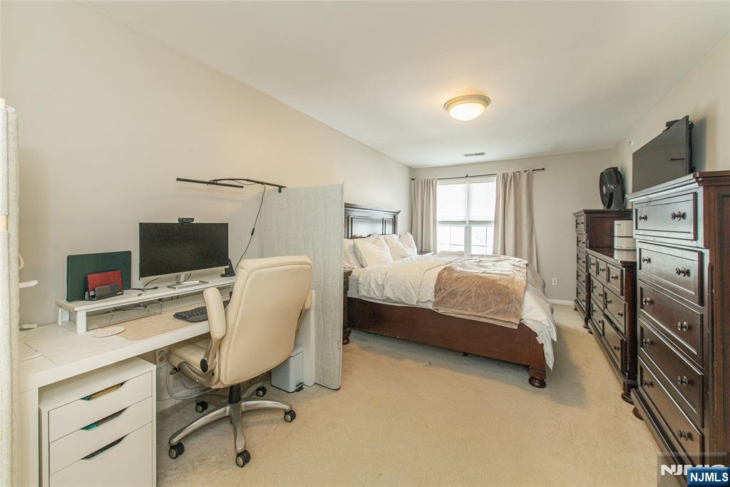 454 Cambridge Drive Butler, NJ 07405 - Photo 10 of 38 a bedroom with a bed and a chair