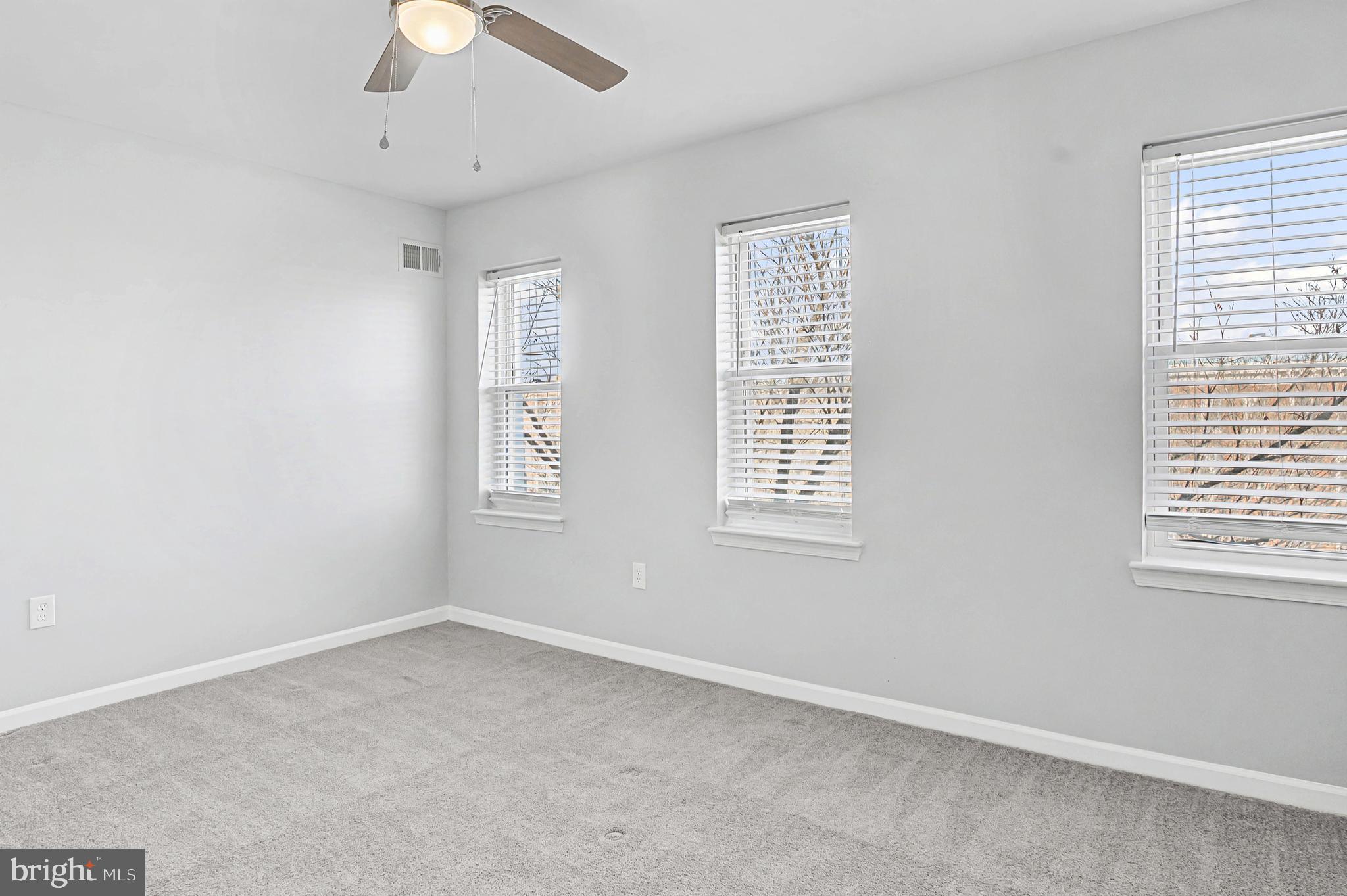 1032 North Broadway Baltimore, MD 21205 - Photo 21 of 28 an empty room with a window and a fan