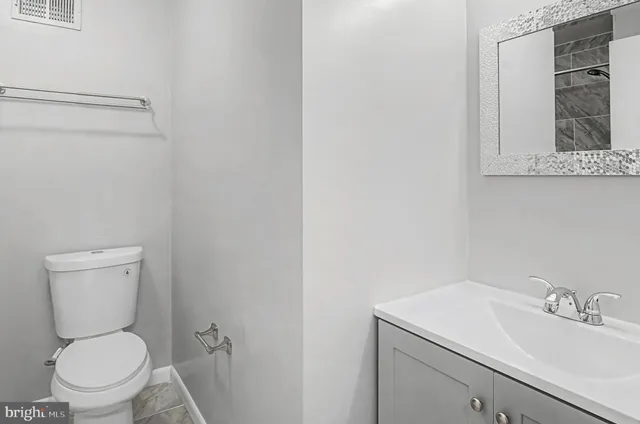 a white toilet sitting next to a bathroom sink