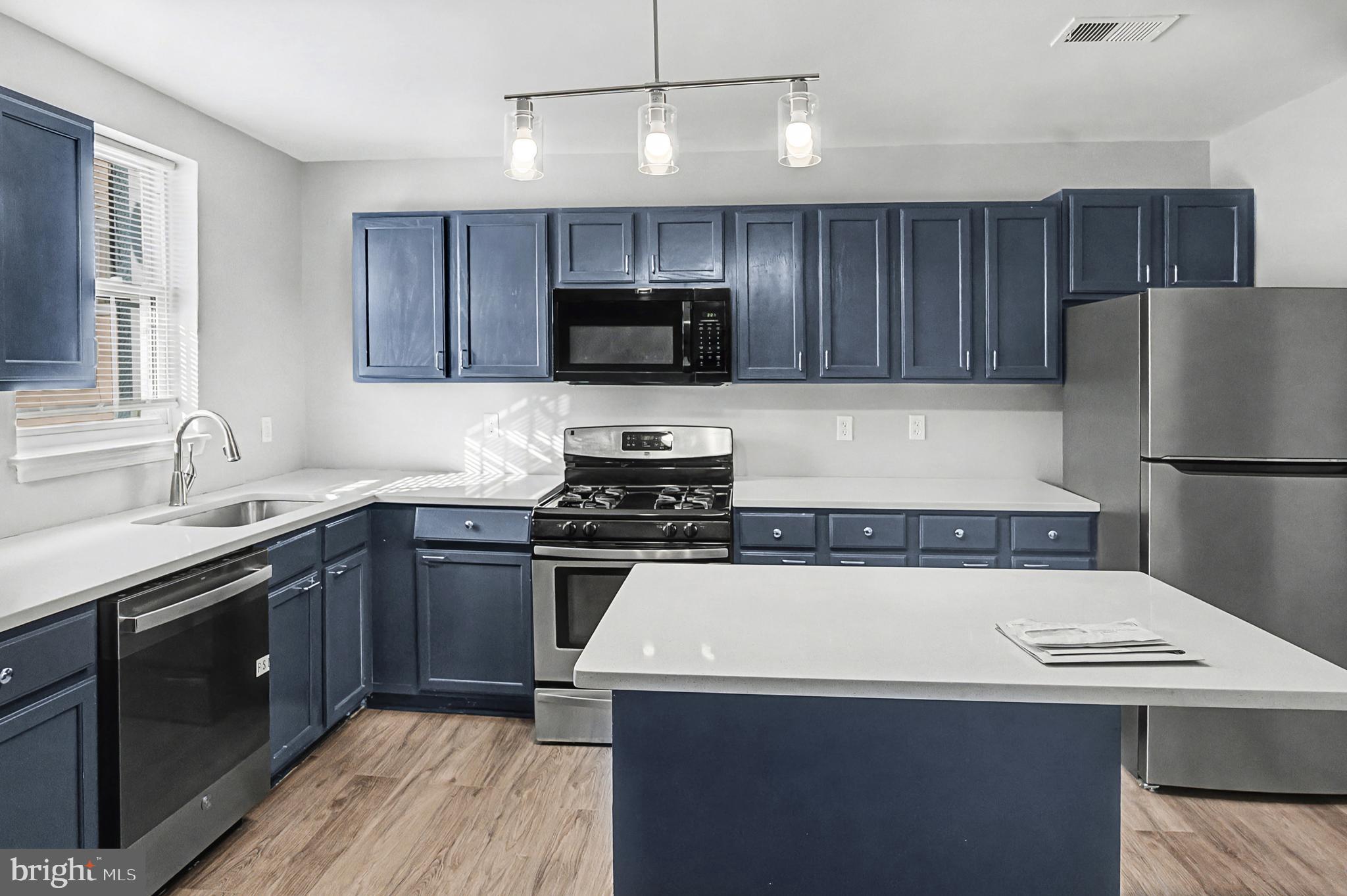1032 North Broadway Baltimore, MD 21205 - Photo 3 of 28 a kitchen with a sink a stove and refrigerator