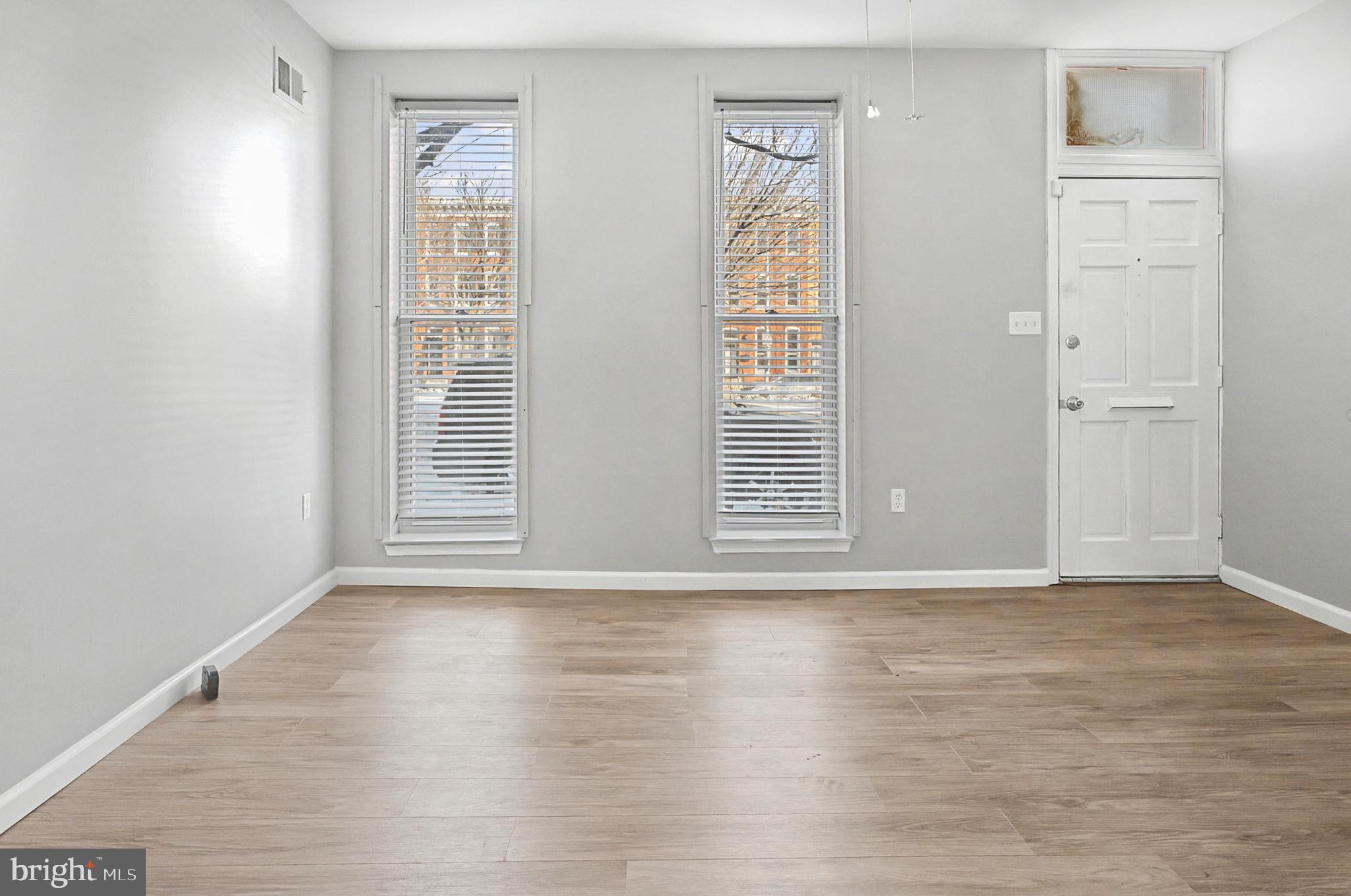 1032 North Broadway Baltimore, MD 21205 - Photo 4 of 28 a view of an empty room with wooden floor and a window