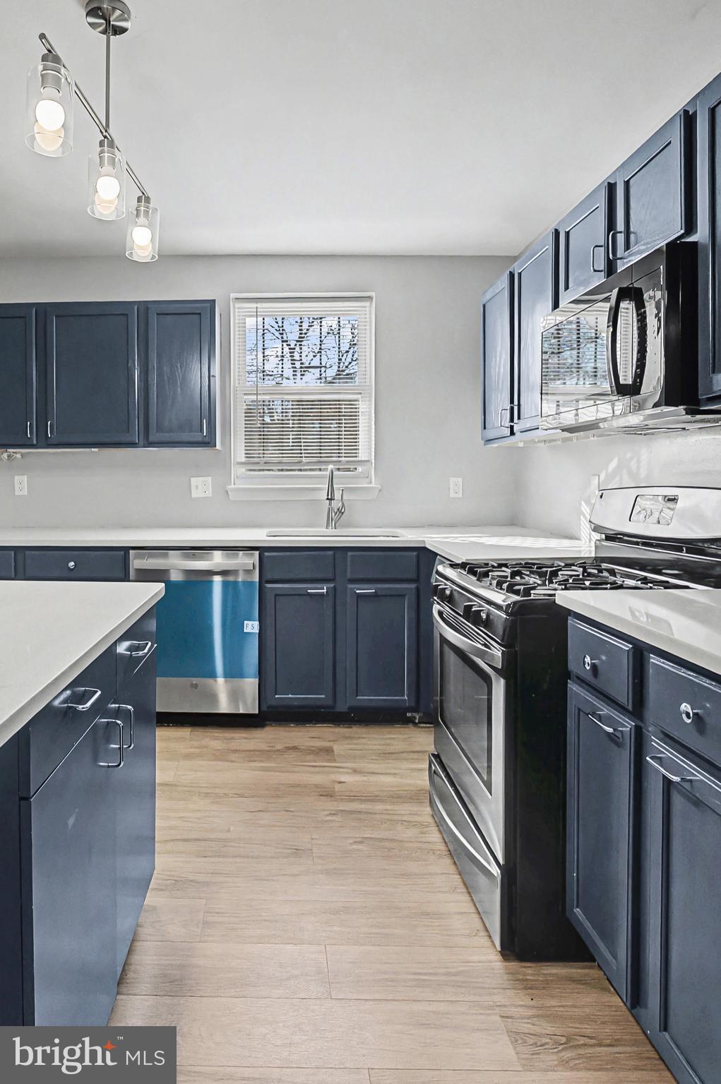 1032 North Broadway Baltimore, MD 21205 - Photo 9 of 28 a kitchen with stainless steel appliances granite countertop a stove a sink and a microwave