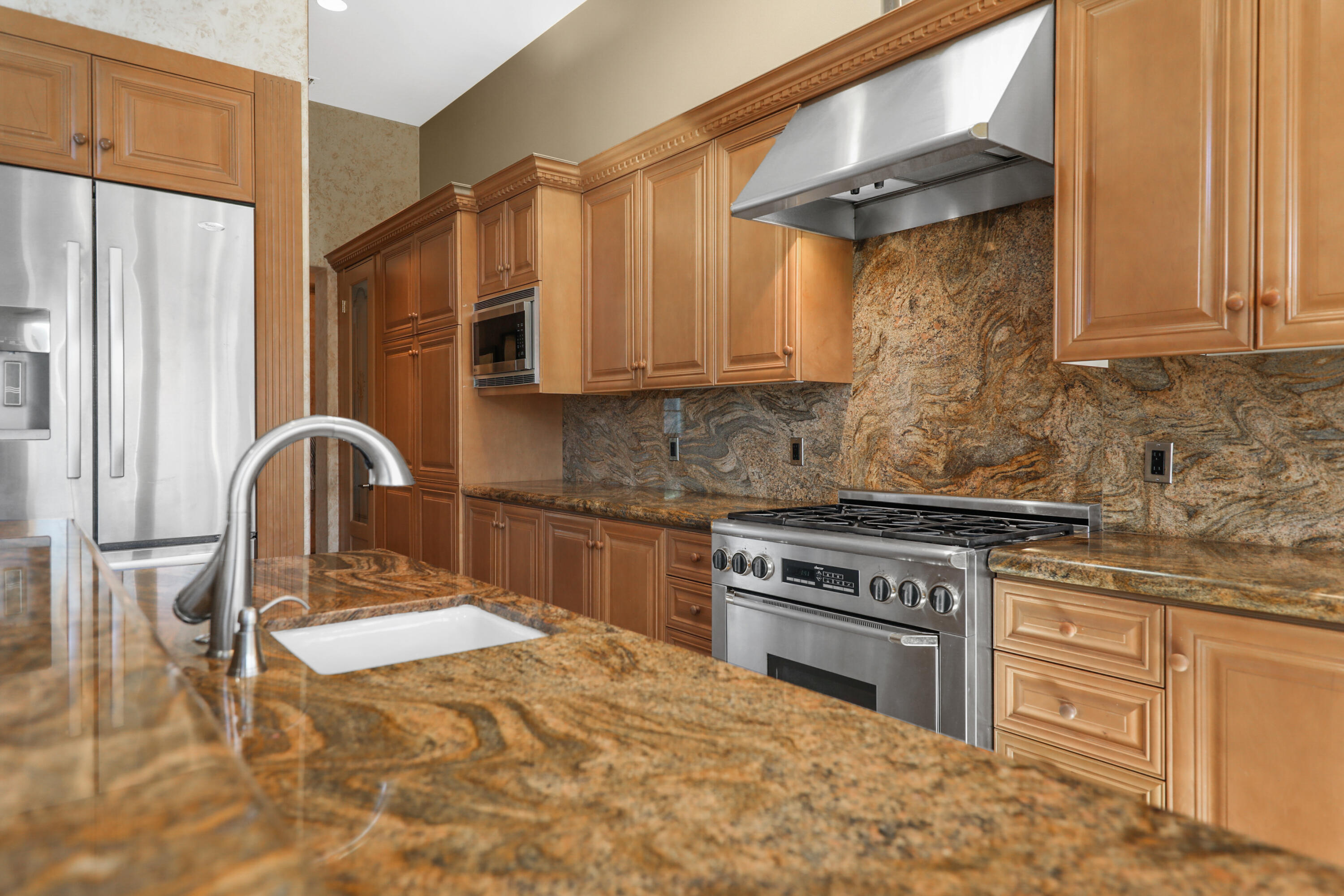 78680 Ave Tujunga La Quinta, CA 92253 - Photo 12 of 41 a kitchen with stainless steel appliances granite countertop a stove a sink and a refrigerator