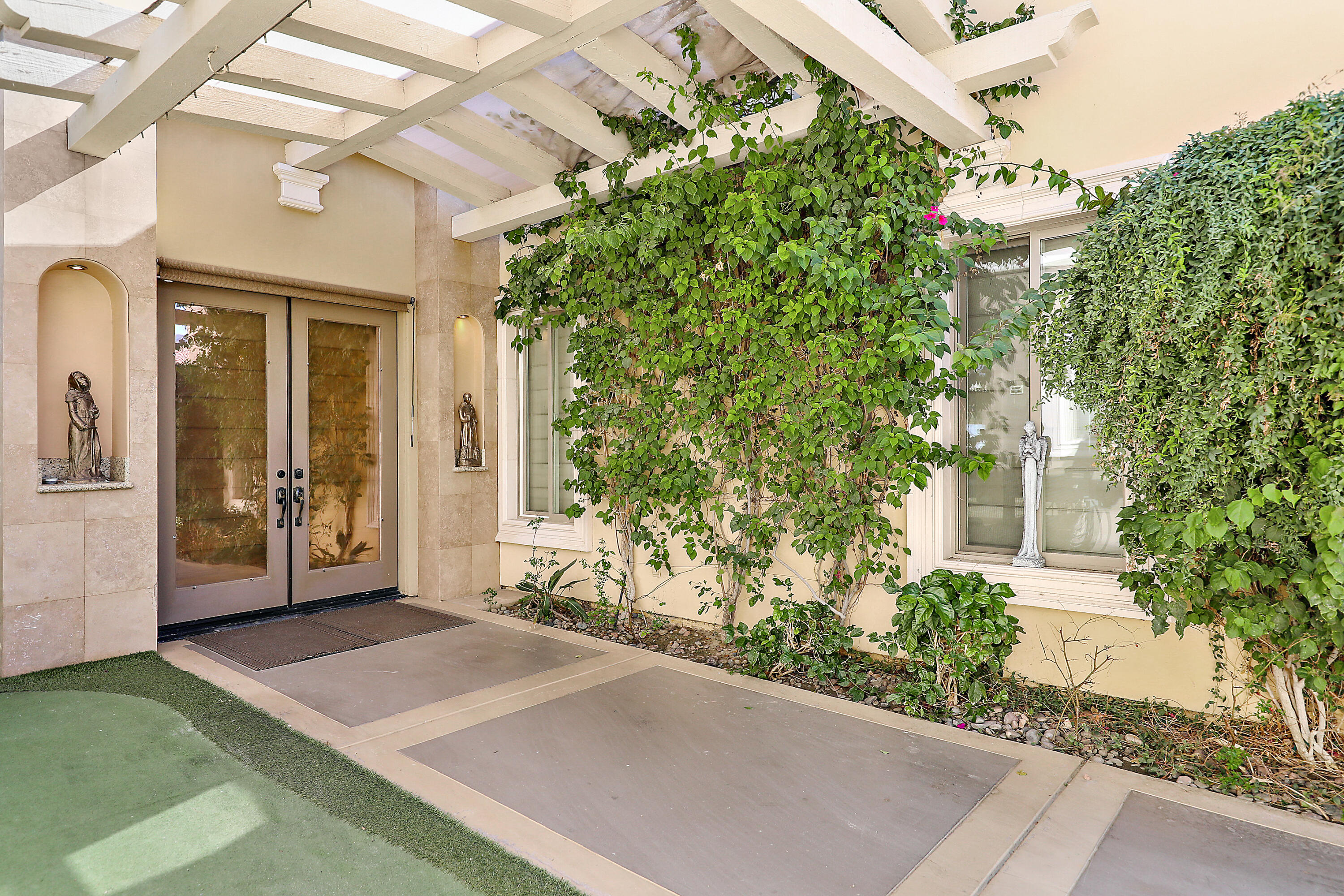 78680 Ave Tujunga La Quinta, CA 92253 - Photo 38 of 41 a view of a large building with large windows and a flower garden