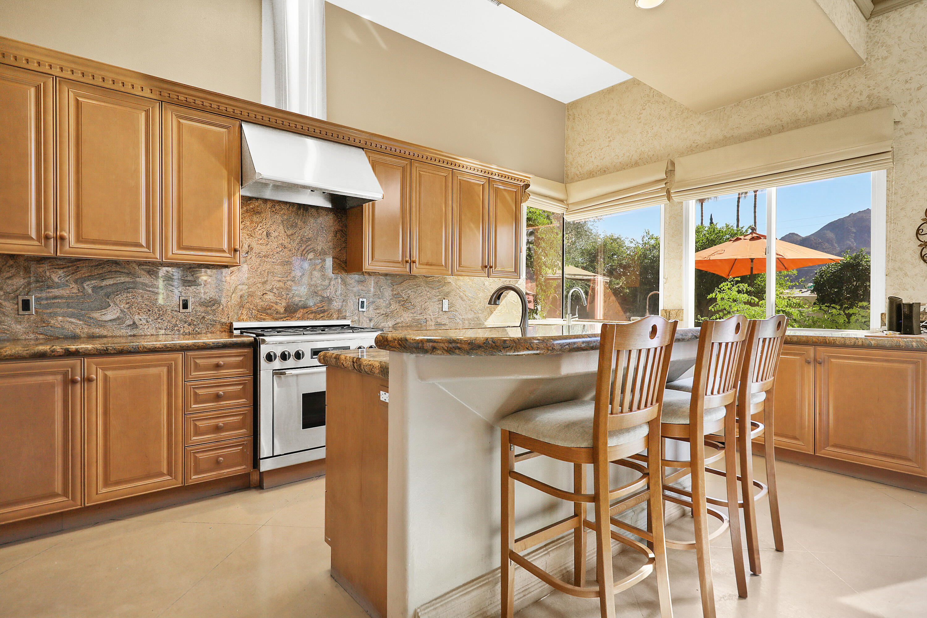 78680 Ave Tujunga La Quinta, CA 92253 - Photo 8 of 41 a kitchen with stainless steel appliances granite countertop a sink and cabinets