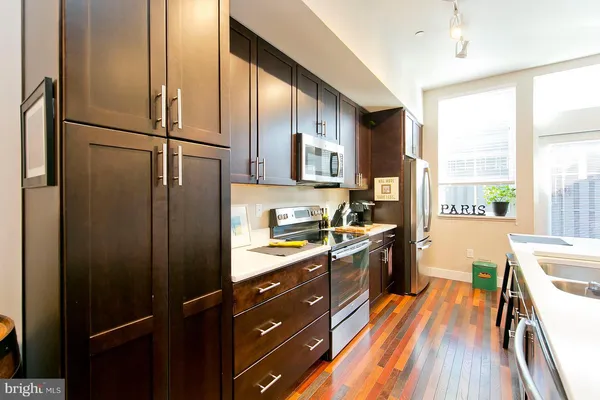 a kitchen with stainless steel appliances a refrigerator sink and cabinets