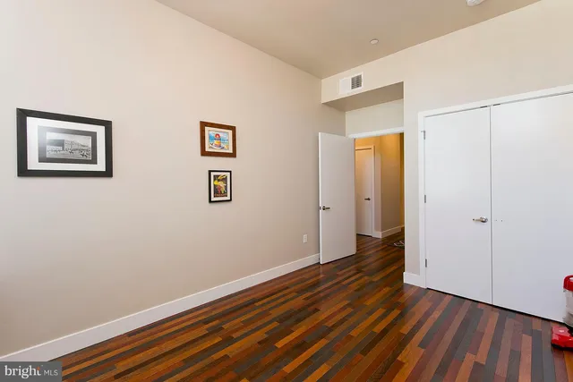 a view of an empty room with wooden floor