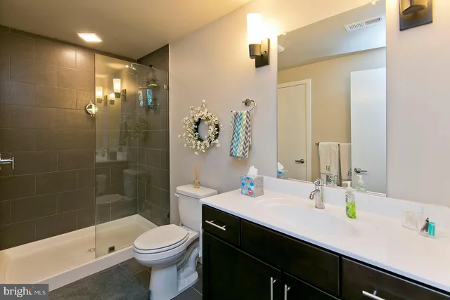 a bathroom with a sink a toilet and shower