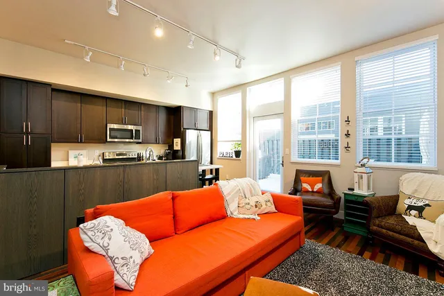 a living room with furniture wooden floor and a view of kitchen