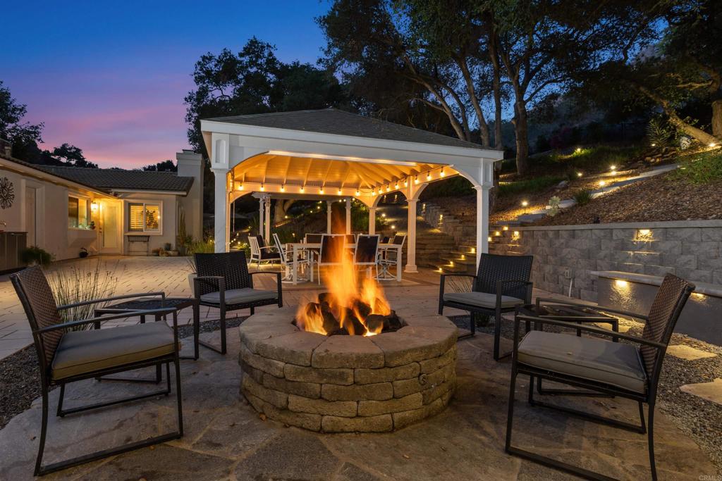 a view of a patio with dining table and chairs with a fire pit